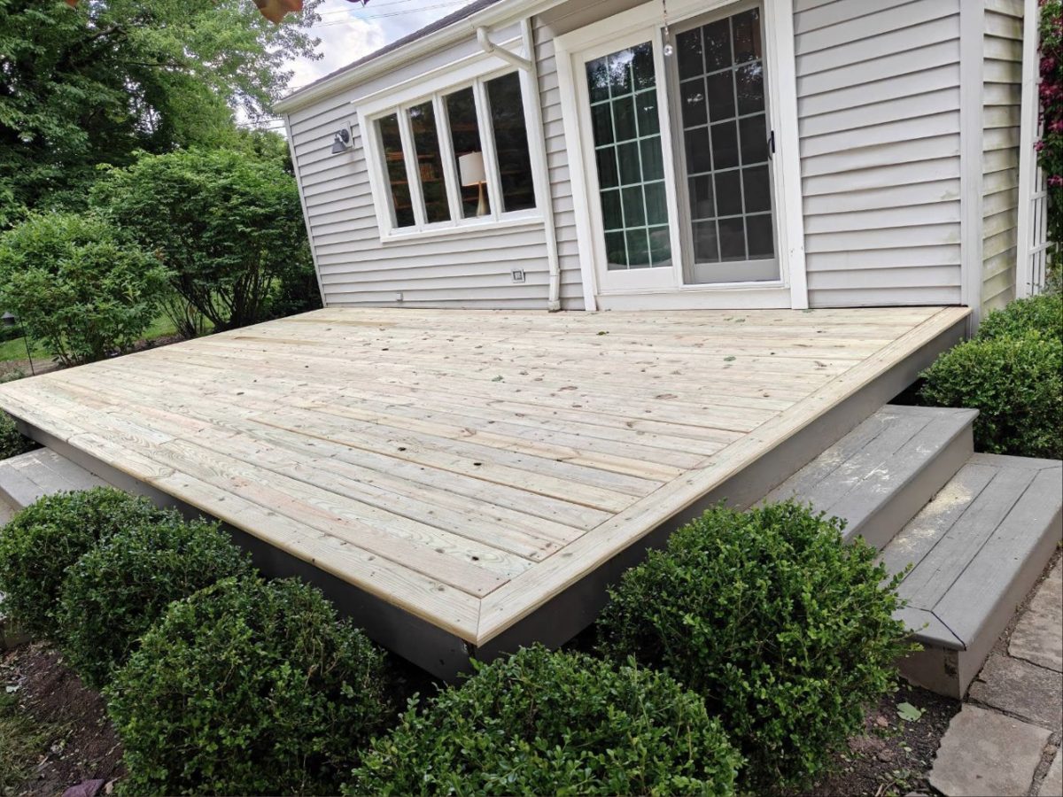 Finished deck with steps, surrounded by boxwood shrubs